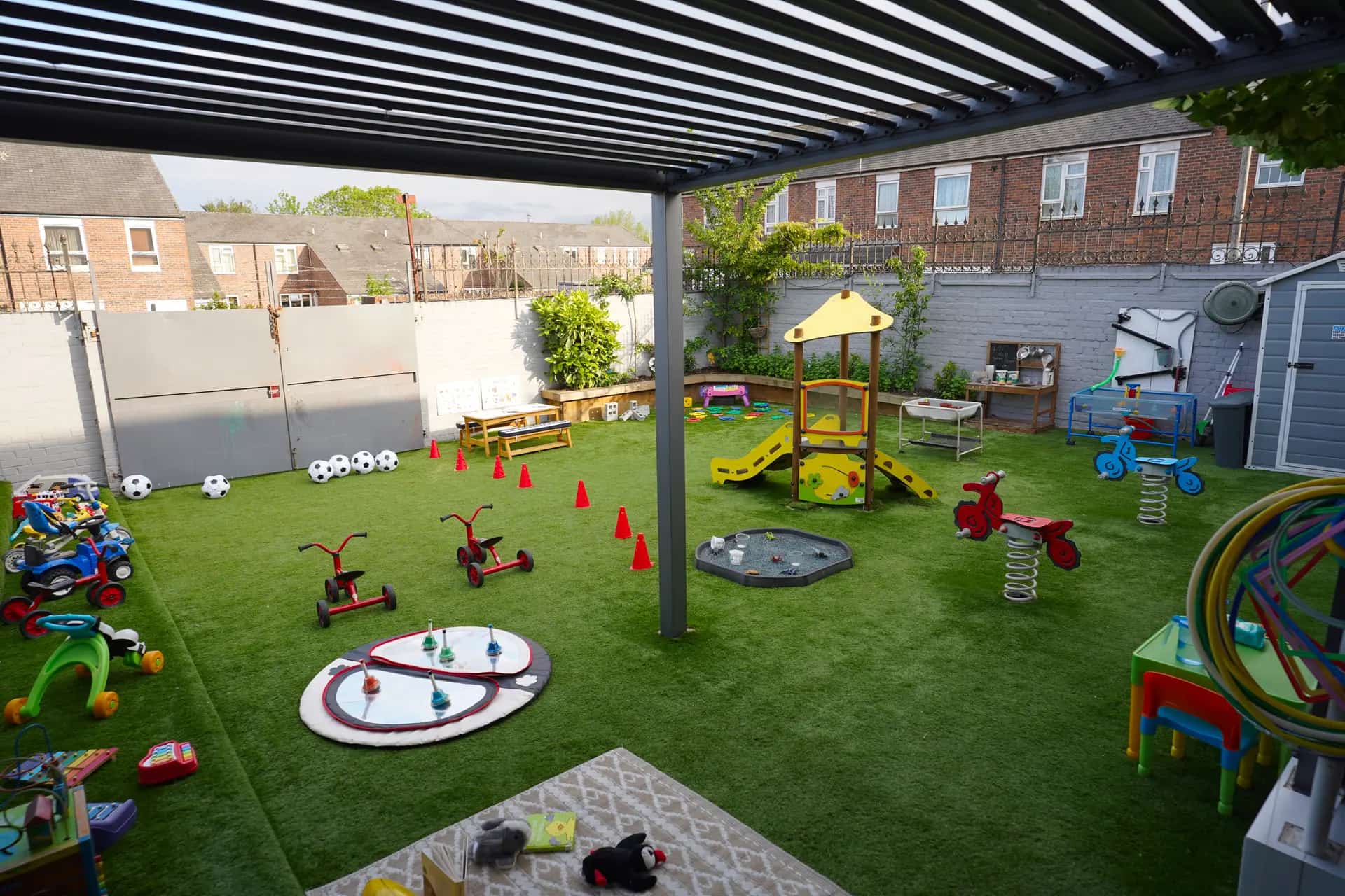 Outdoor learning playground under the pergola at Blue Nest Montessori Borehamwood