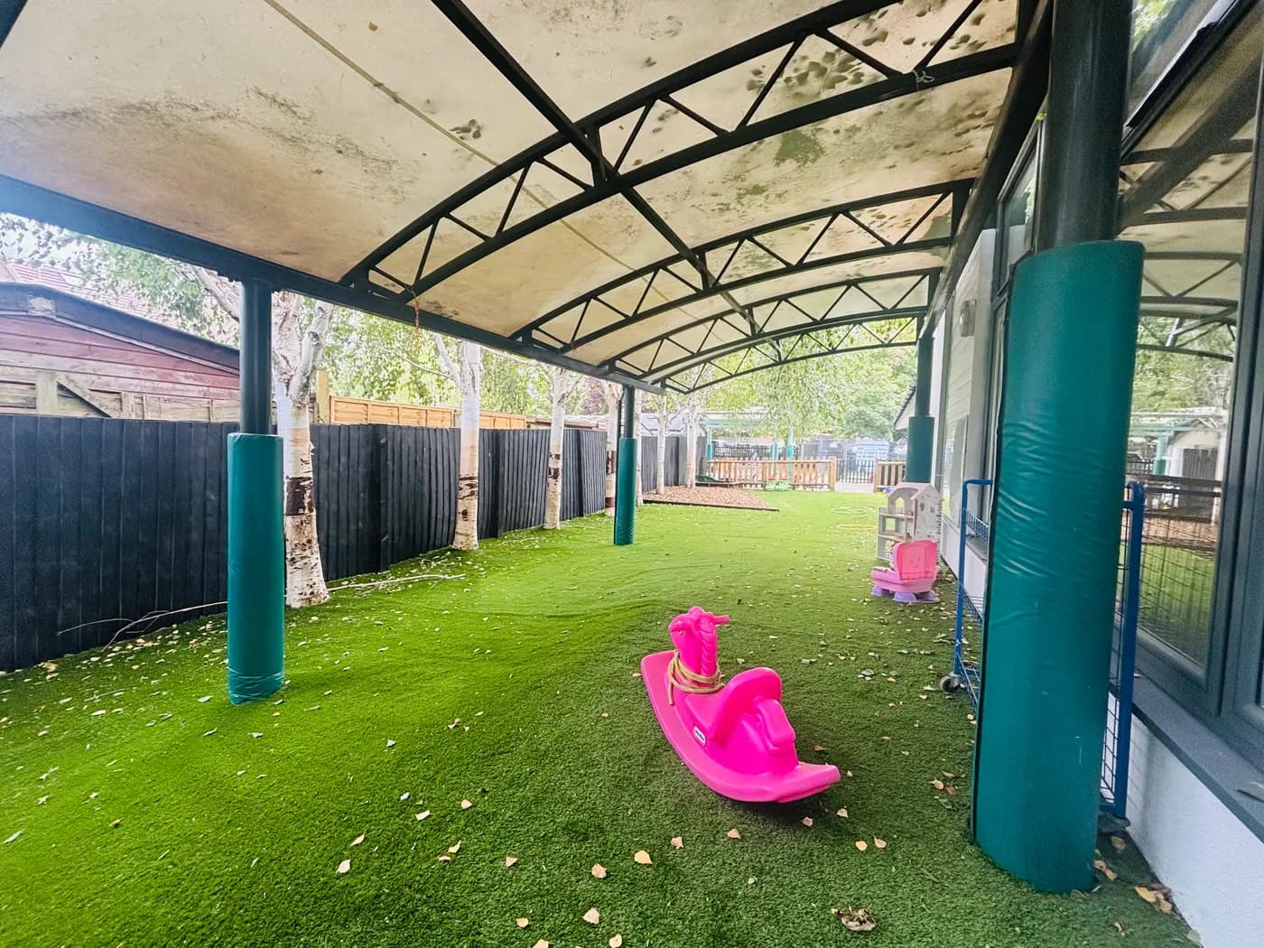 The all-weather canopy play area with a pink rocking horse at Blue Nest Montessori Aldershot