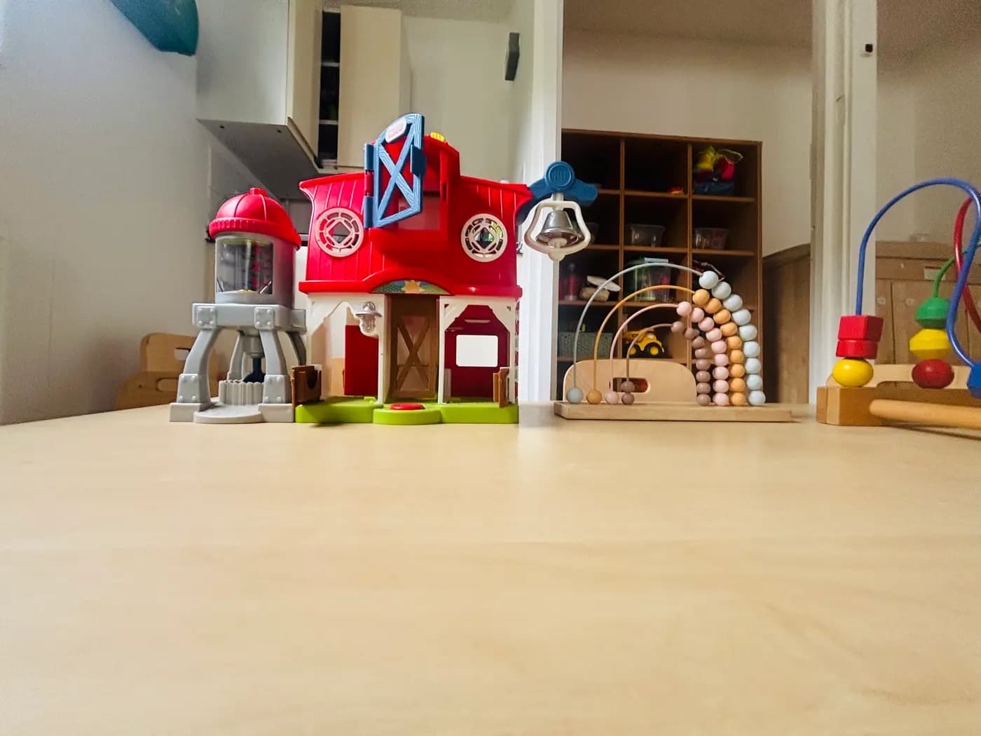 A farm playset, pastel abacus and bead maze set out on a low table at Blue Nest Montessori Aldershot
