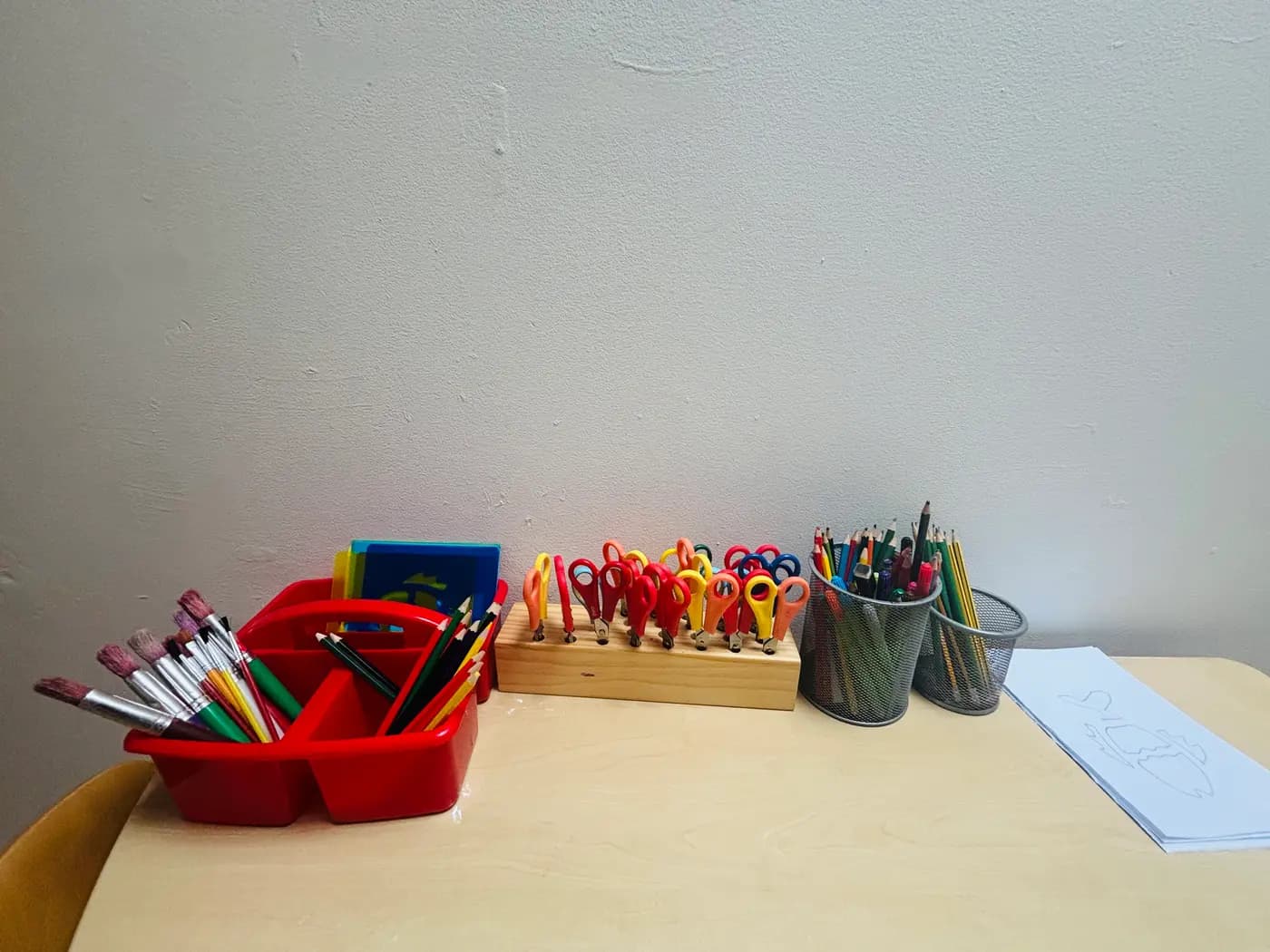 Paint brushes, child-safe scissors and pencils set out at the art station at Blue Nest Montessori Aldershot