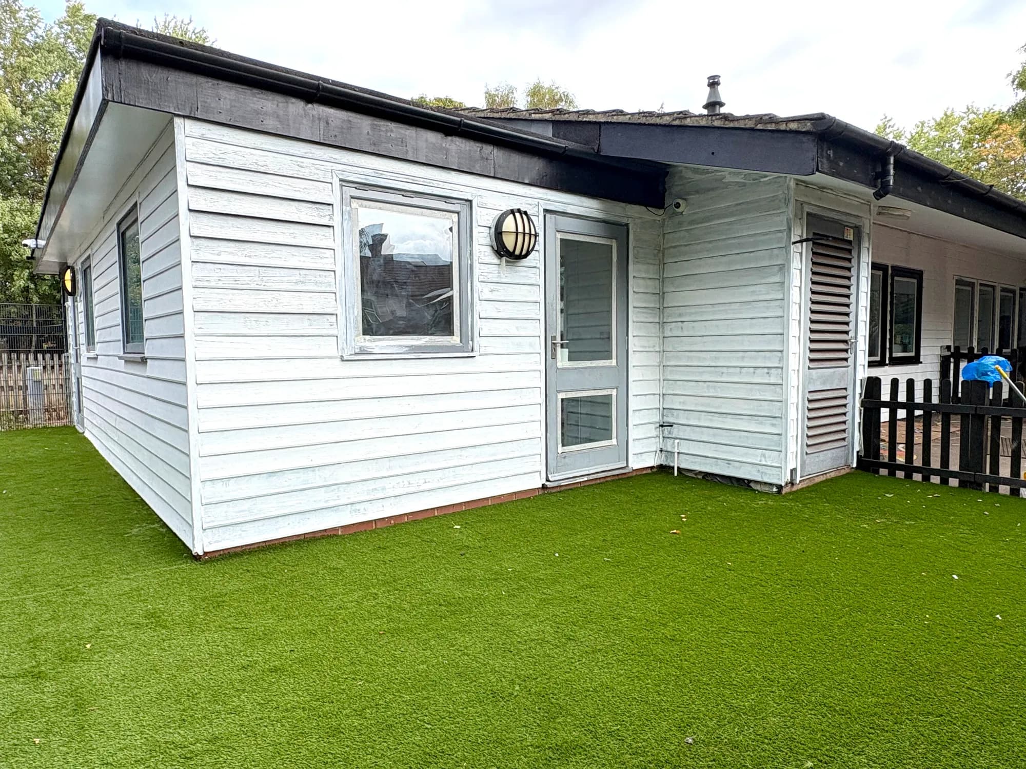 The Blue Nest Montessori Aldershot nursery building and artificial-lawn garden