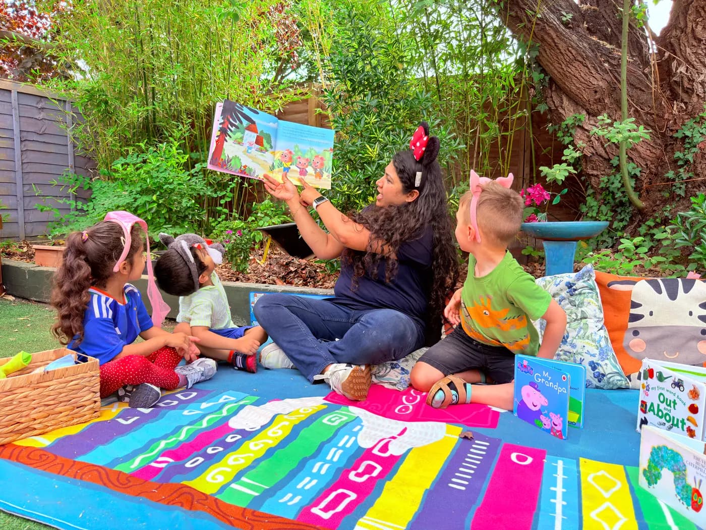 Children gathered for a group activity on the mat outdoors at Blue Nest Pinner