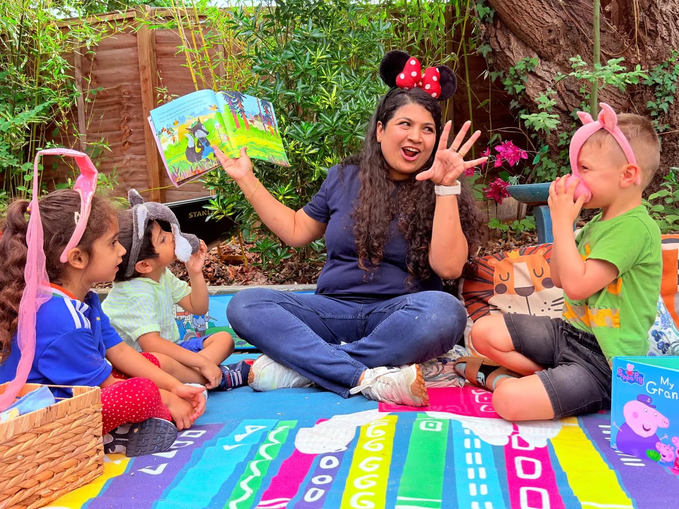 Children playing with toys on a mat in the Blue Nest Pinner garden