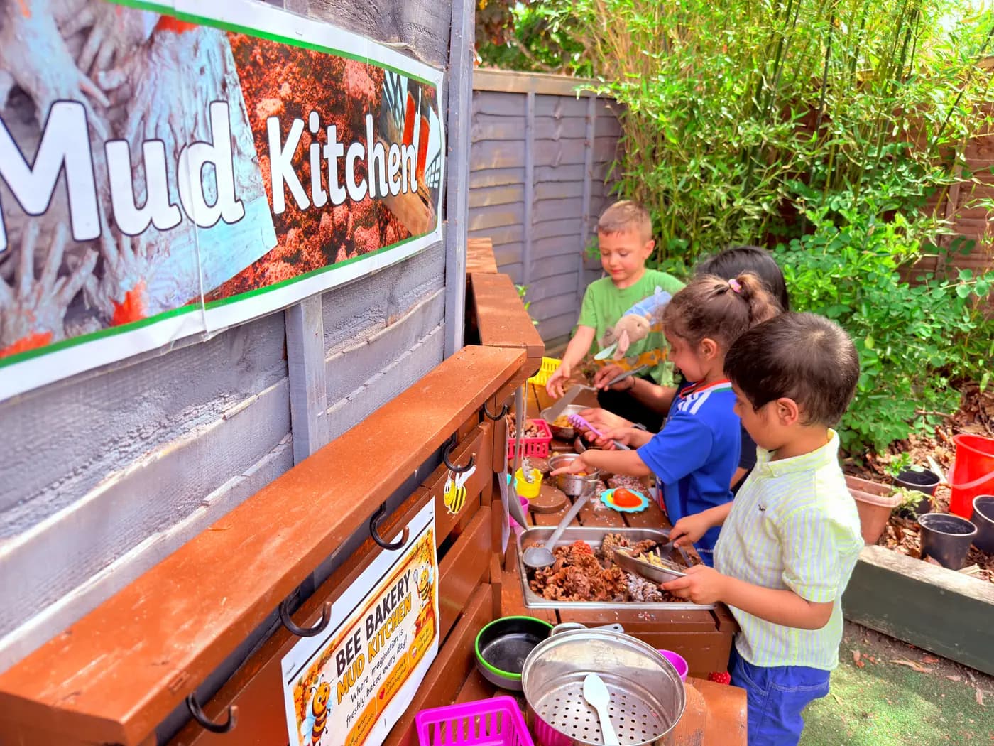 A child playing at the outdoor mud kitchen at Blue Nest Pinner