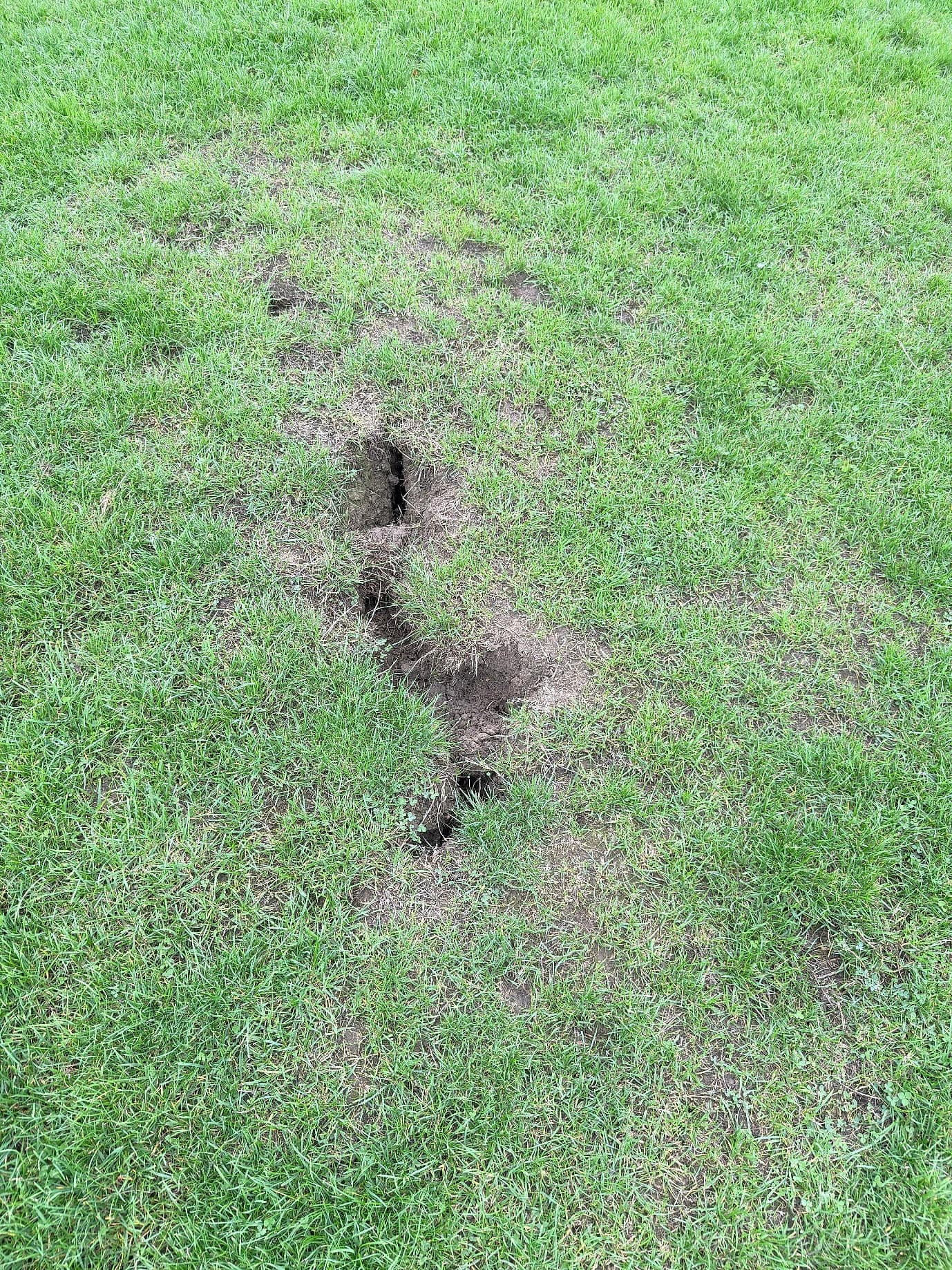 A hole in the grass before being filled