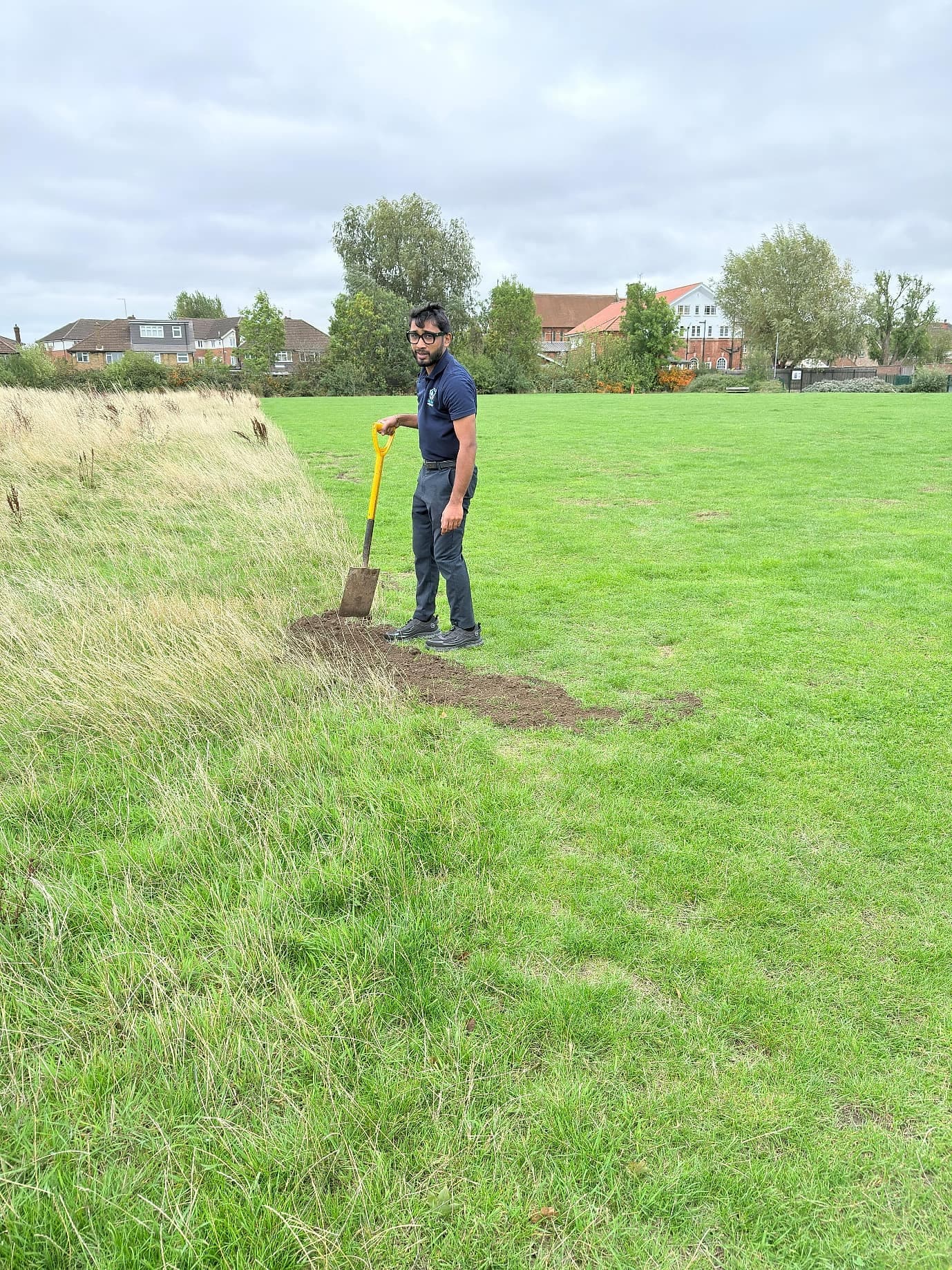 Wide open grassland at Headstone Green Park with homes beyond