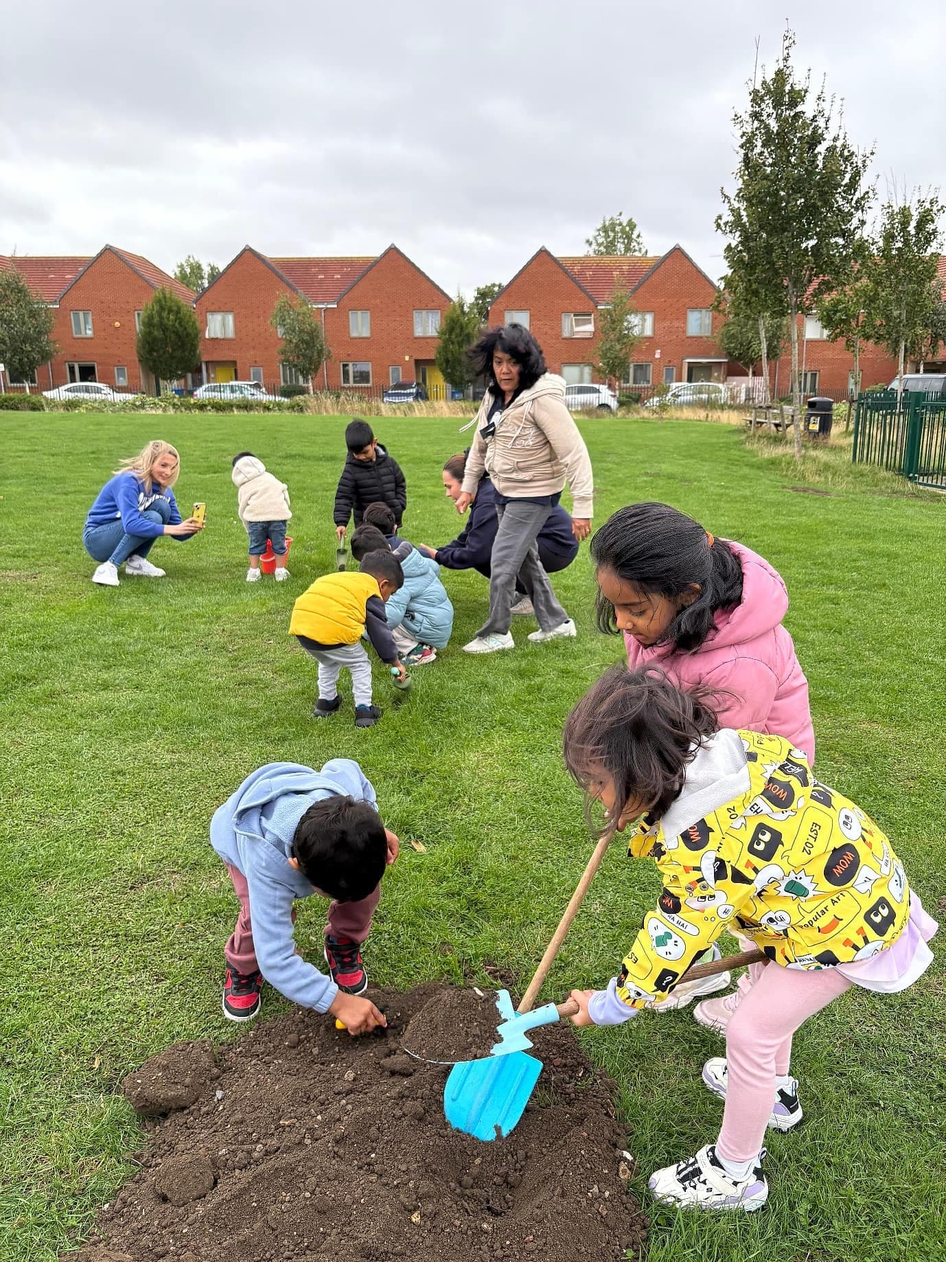 Children and families filling holes in the grass together during the September 2025 community day