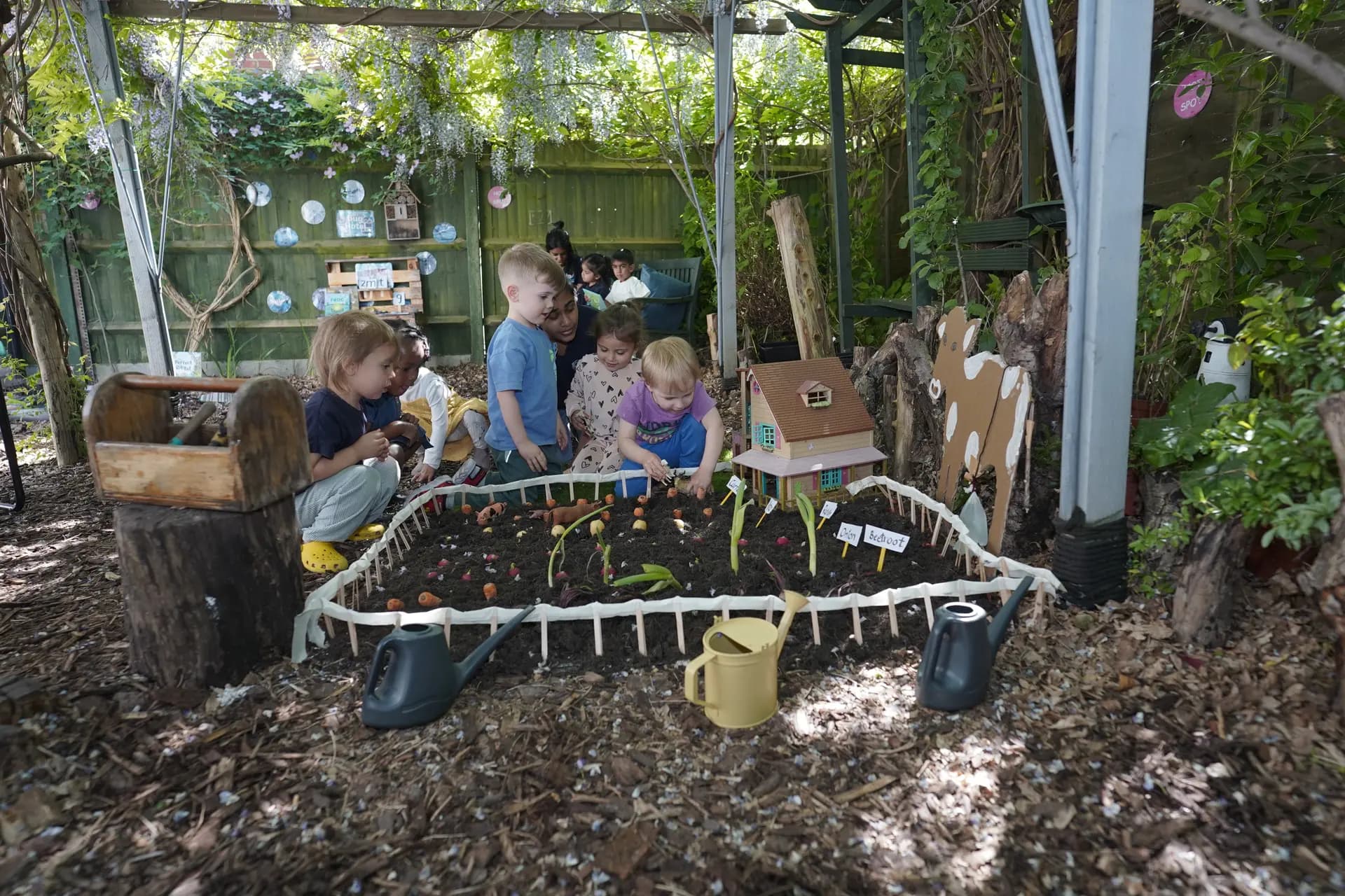 Children planting in the garden bed at Blue Nest Harrow